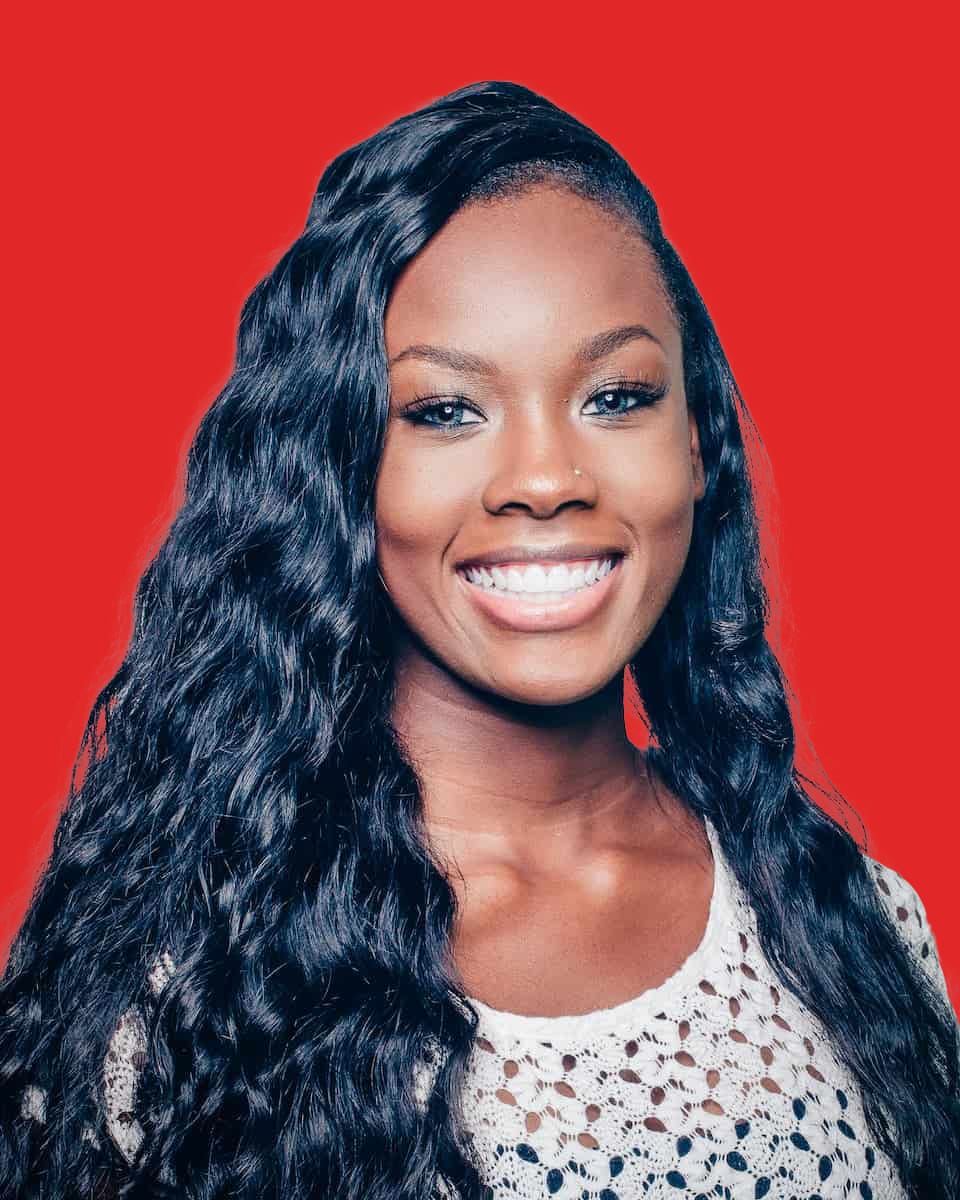 Smiling woman with long curly hair, red background.