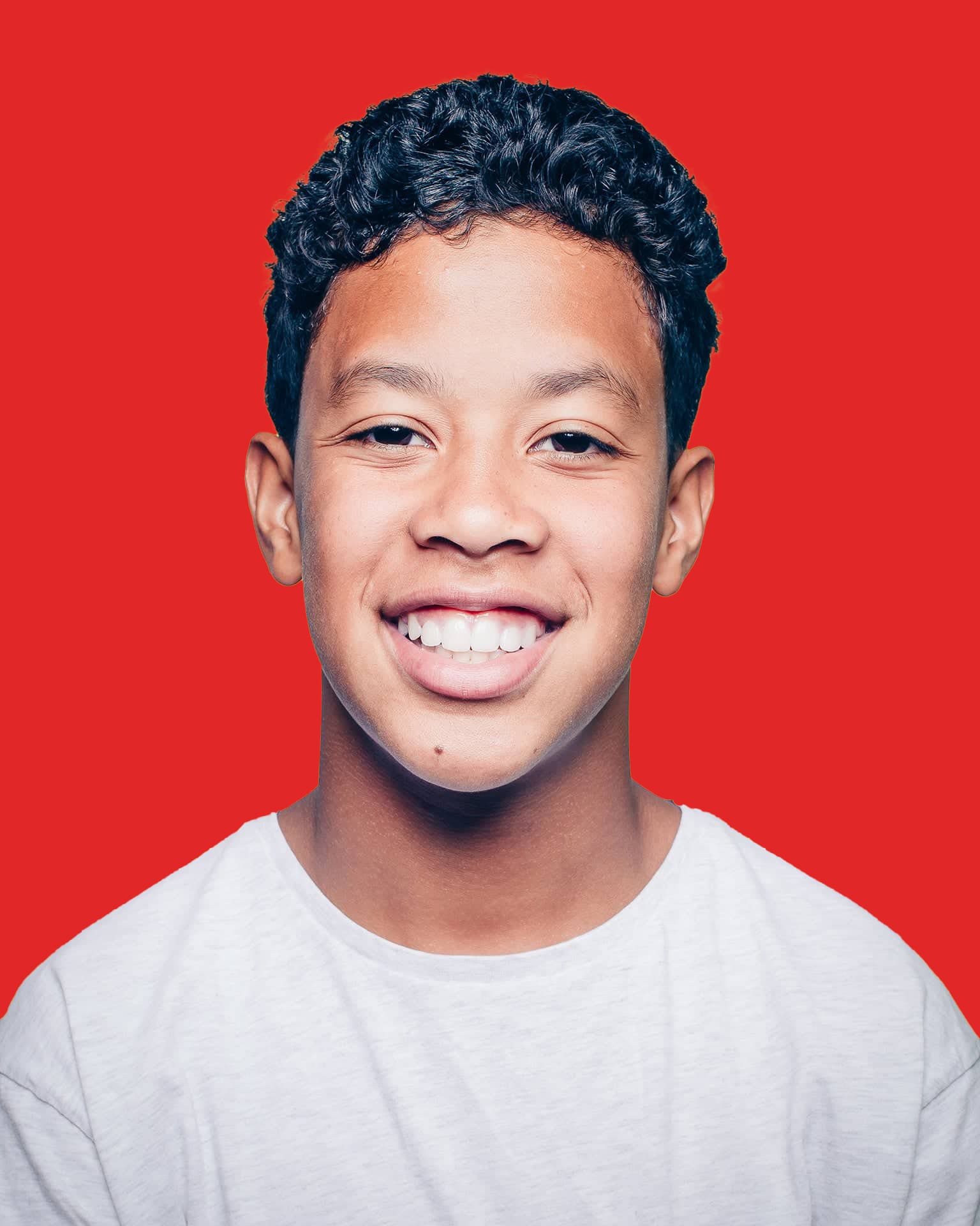 Smiling person with curly hair, red background